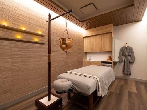 A calm treatment room at Carlisle Massage & Spa with a massage table, warm candlelight and wood-panelled walls